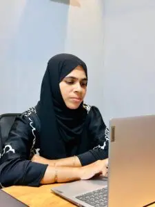 A women wearing a black hijab working on a laptop